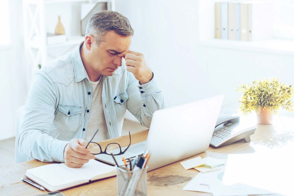 Meneer achter een laptop die niet weet wat seo betekent.